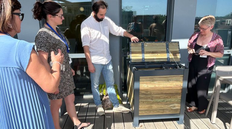 Salarié autour d'un compoteur à planter sur la terrasse d'une entreprise